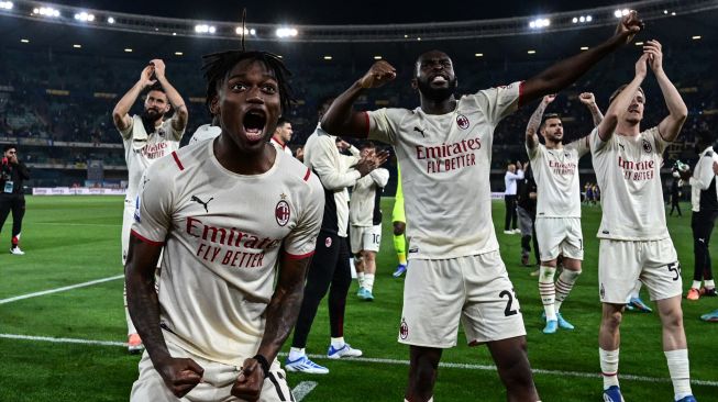 Penyerang AC Milan Rafael Leao (kiri), bek AC Milan Fikayo Tomori (tengah) dan para pemain AC Milan berselebrasi ke hadapan penonton saat akhir pertandingan sepak bola Serie A Liga Italia antara Hellas Verona melawan AC Milan di Stadion Marcantonio Bentegodi, Verona, Italia, Minggu (8/5/2022). [Miguel MEDINA / AFP]