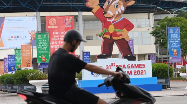 Pengendara sepeda motor melintasi gambar maskot SEA Games 2021 Vietnam, Hanoi Saola, di Kota Bac Ninh, Vietnam, Minggu (8/5/2022). [ANTARA FOTO/Aditya Pradana Putra/YU]