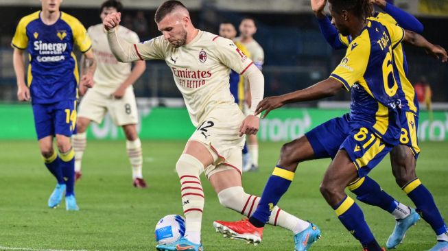 Penyerang AC Milan Ante Rebic (kiri) mengungguli gelandang Hellas Verona Adrien Tameze (kanan) ketika memperebutkan bola saat pertandingan sepak bola Serie A Liga Italia antara Hellas Verona melawan AC Milan di Stadion Marcantonio Bentegodi, Verona, Italia, Minggu (8/5/2022). [Miguel MEDINA / AFP]