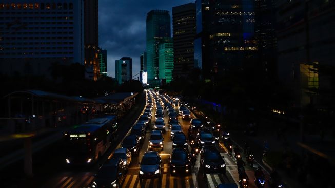 Sejumlah kendaraan terjebak kemacetan di Jalan Sudirman, Jakarta Pusat, Senin (9/5/2022). [Suara.com/Alfian Winanto]