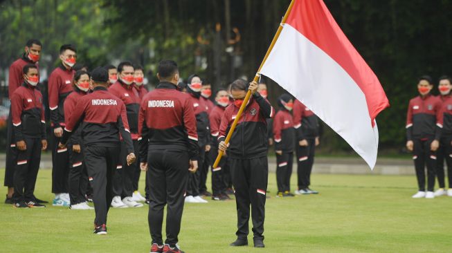 Menpora Zainudin Amali (kanan) menyerahkan Bendera Merah Putih kepada Chef de Mission (CdM) kontingen Indonesia Ferry Kono Untuk SEA Games 2021 saat pelepasan kontingen Indonesia di halaman Istana Merdeka, Jakarta, Senin (9/5/2022). [ANTARA FOTO/Hafidz Mubarak A/rwa]
