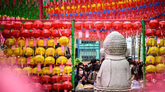 Para Jemaat berdoa setelah kebaktian saat peraayan Hari Kelahiran Buddha di Kuil Jogye, Seoul, Korea Selatan, Minggu (8/5/2022). [ANTHONY WALLACE / AFP]