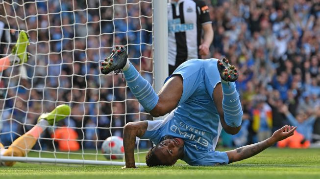 Reaksi gelandang Manchester City Raheem Sterling setelah berhasil mencetak gol saat pertandingan sepak bola Liga Premier Inggris antara Manchester City dan Newcastle United di Stadion Etihad, Manchester, Inggris, Minggu (8/5/2022). [Paul ELLIS / AFP]