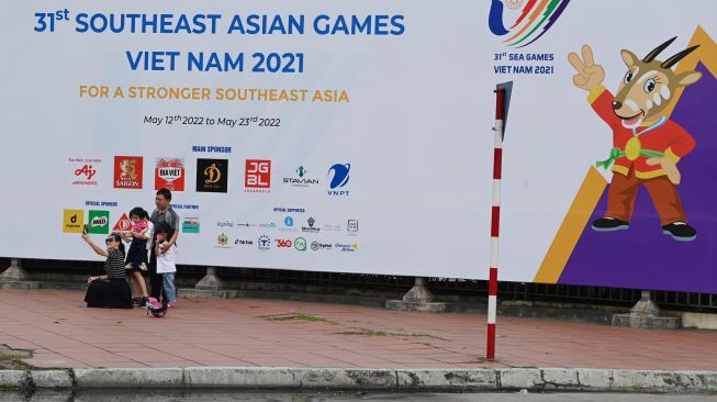 Warga berswa foto dengan latar belakang gambar maskot SEA Games 2021 Vietnam, Hanoi Saola, di Kota Hanoi, Vietnam, Minggu (8/5/2022). [ANTARA FOTO/Aditya Pradana Putra/YU]