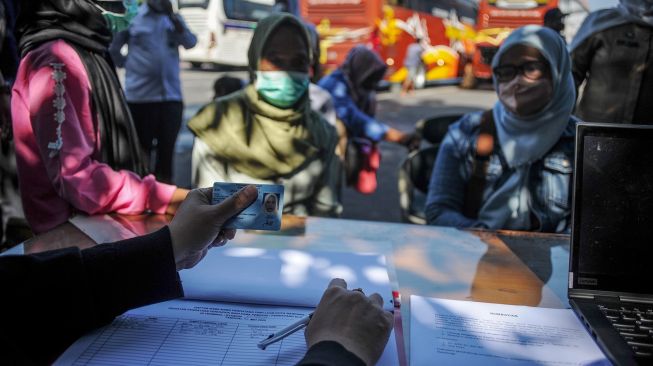 Petugas Disdukcapil Kota Bandung melakukan pencatatan bagi para pendatang yang baru tiba di Terminal Cicaheum, Bandung, Jawa Barat, Selasa (10/5/2022).  ANTARA FOTO/Raisan Al Farisi