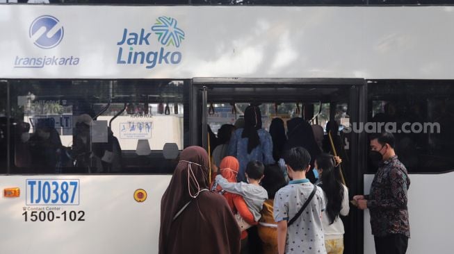 Warga memasuki bus wisata gratis Transjakarta di Jakarta, Selasa (10/5/2022). [Suara.com/Angga Budhiyanto]