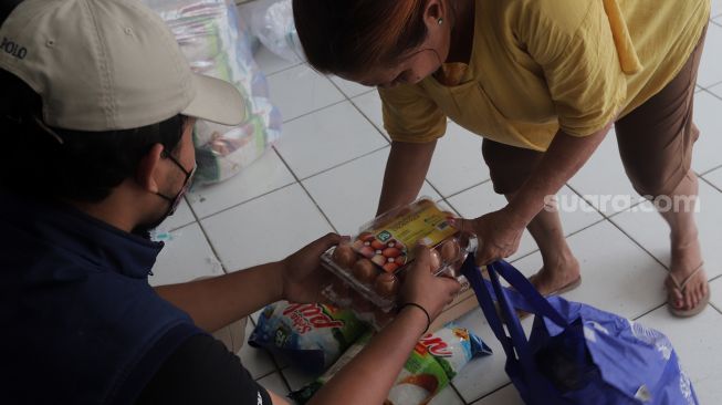 Warga membeli pangan bersubsidi di Rumah Susun Jatinegara Kaum, Jakarta, Rabu (11/5/2022). [Suara.com/Angga Budhiyanto]