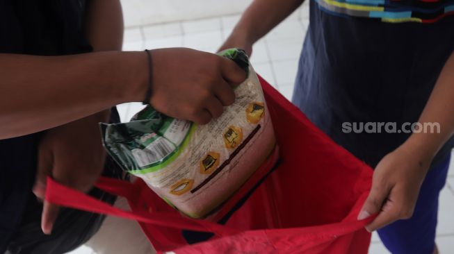 Warga membeli pangan bersubsidi di Rumah Susun Jatinegara Kaum, Jakarta, Rabu (11/5/2022). [Suara.com/Angga Budhiyanto]