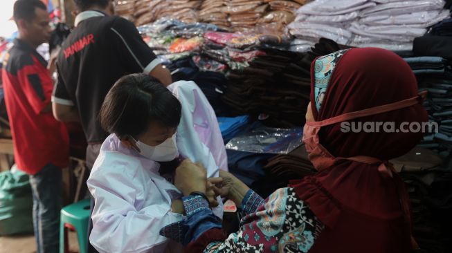 Calon pembeli memilih seragam sekolah di Pasar Jatinegara, Jakarta, Rabu (11/5/2022). [Suara.com/Angga Budhiyanto]