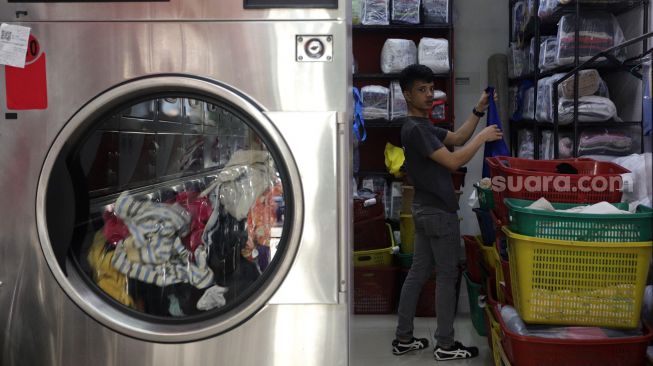 Pekerja memilah pakaian milik pelanggan untuk dikemas di Jourdan Laundry Expert, Ampera Raya, Jakarta, Rabu (11/5/2022). [Suara.com/Angga Budhiyanto]