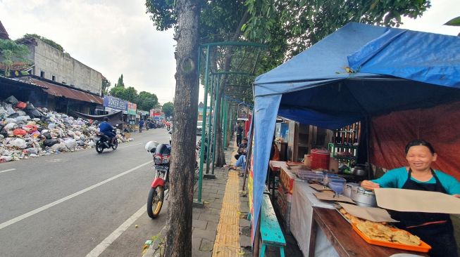 Penumpukan sampah di TPS Lempuyangan yang meluber hingga ke jalan, Rabu (11/5/2022). [Hiskia Andika Weadcaksana/SuaraJogja.id]