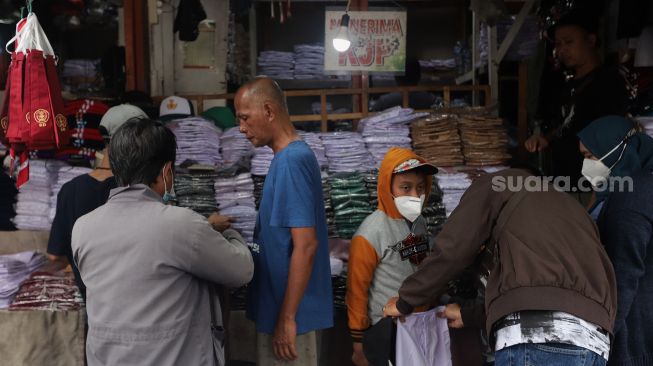 Calon pembeli memilih seragam sekolah di Pasar Jatinegara, Jakarta, Rabu (11/5/2022). [Suara.com/Angga Budhiyanto]