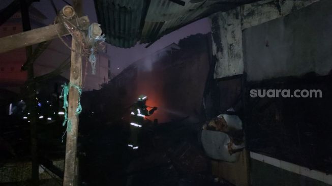Petugas pemadam kebakaran masih berjibaku memadamkan api yang melalap habis ratusan lapak pedagang dan sejumlah rumah warga di Pasar Ciputat, Kota Tangerang Selatan (Tangsel), Rabu (11/5/2022) malam. [SuaraJakarta.id/Wivy Hikmatullah]