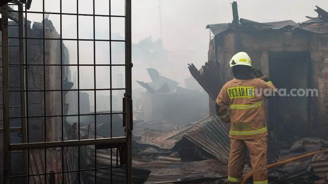 Petugas tengah berupaya memadamkan kebakaran yang menghanguskan ratusan lapak daging di Pasar Ciputat, Kota Tangerang Selatan (Tangsel), Rabu (11/5/2022) sore. [SuaraJakarta.id/Wivy Hikmtullah]