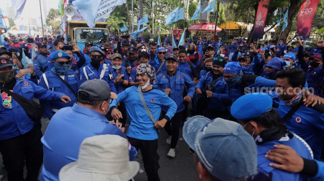 Sejumlah massa buruh berjoget saat melakukan aksi unjuk rasa di kawasan Patung Kuda Arjuna Wiwaha, Jakarta, Kamis (12/5/2022). [Suara.com/Angga Budhiyanto]