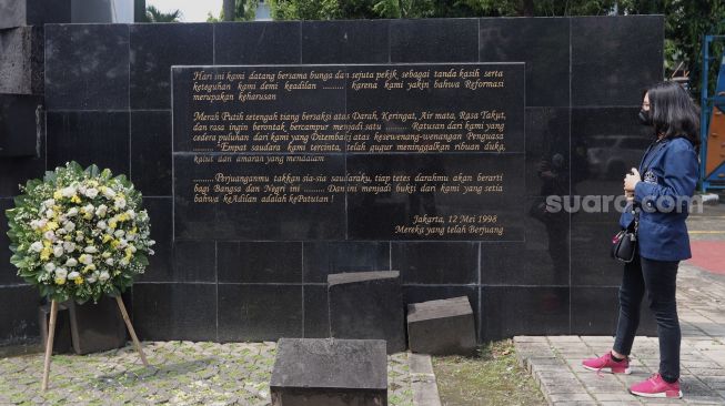 Seorang mahasiswi mengamati Monumen Reformasi 12 Mei 1998 Universitas Trisakti saat peringatan Tragedi Trisakti 12 Mei 1998 di Jakarta, Kamis (12/5/2022). [Suara.com/Angga Budhiyanto]