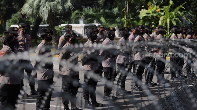 Aparat kepolisian melakukan pengamanan saat massa buruh melakukan aksi unjuk rasa di kawasan Patung Kuda Arjuna Wiwaha, Jakarta, Kamis (12/5/2022). [Suara.com/Angga Budhiyanto]