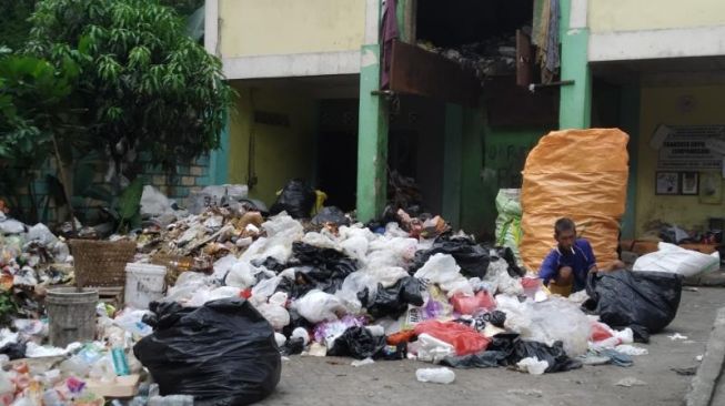 Seorang pengelola sampah di transfer depo sampah Lempongsari, Sariharjo, Ngaglik, Kabupaten Sleman sedang memilah sampah. (kontributor/uli febriarni) 