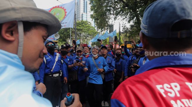 Sejumlah massa buruh berjoget saat melakukan aksi unjuk rasa di kawasan Patung Kuda Arjuna Wiwaha, Jakarta, Kamis (12/5/2022). [Suara.com/Angga Budhiyanto]