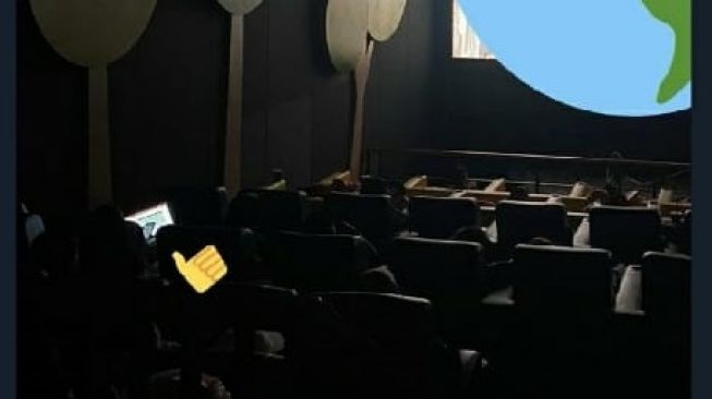 Pengunjung bioskop mengerjakan deadline saat sedang menonton (Twitter/@collegemenfess).