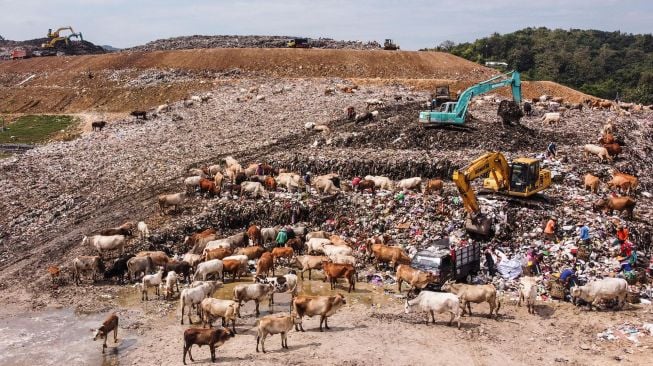 Pekerja memindahkan tumpukan sampah di Tempat Pembuangan Sampah Terpadu (TPST) Piyungan, Bantul, DI Yogyakarta, Kamis (12/5/2022).  ANTARA FOTO/Hendra Nurdiyansyah