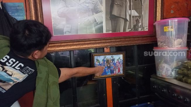 Salah seorang anggota keluarga tengah menunjukkan foto A, bocah yang meninggal diduga akibat terjangkit hepatitis akut di Tamansari, Jakarta Barat, Kamis (12/5/2022). [Suara.com/Faqih Fathurrahman]