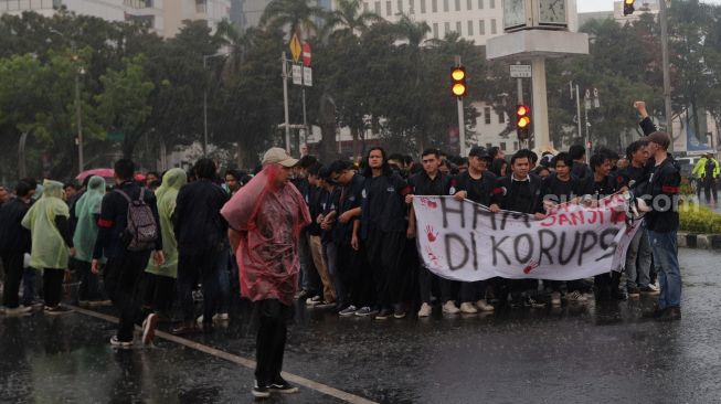 Sejumlah massa mahasiswa Universitas Trisakti menggelar aksi unjuk rasa memperingati Tragedi Trisakti 1998 di kawasan Patung Kuda Arjuna Wiwaha, Jakarta, Kamis (12/5/2022). [Suara.com/Angga Budhiyanto]