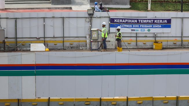 Para pekerja beraktivitas di proyek revitalisasi Halte TransJakarta Sarinah, Jakarta Pusat, Jumat (13/5/2022). [Suara.com/Alfian Winanto]
