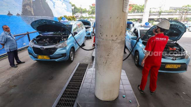 Petugas melakukan pengisian Bahan Bakar Gas (BBG) di Stasiun Pengisian Bahan Bakar Gas (SPBG) Mampang, Jakarta Selatan, Jumat (13/5/2022). [Suara.com/Alfian Winanto]