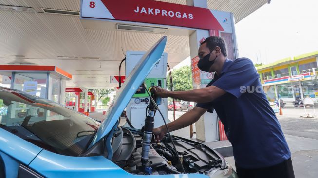 Petugas melakukan pengisian Bahan Bakar Gas (BBG) di Stasiun Pengisian Bahan Bakar Gas (SPBG) Mampang, Jakarta Selatan, Jumat (13/5/2022). [Suara.com/Alfian Winanto]