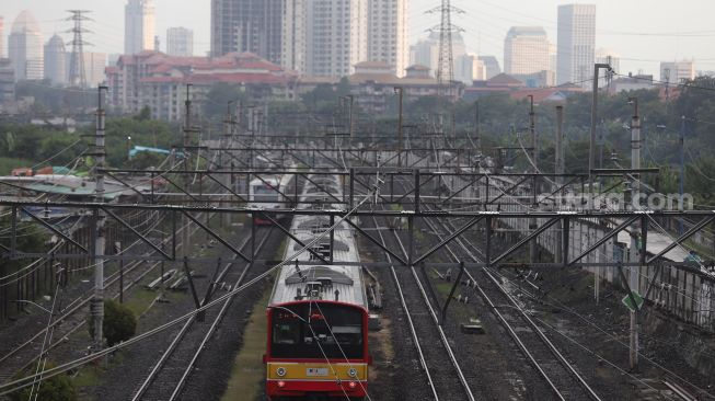 Rangkaian KRL Commuter Line melintas di kawasan Tanah Abang, Jakarta, Jumat (13/5/2022). [Suara.com/Angga Budhiyanto]