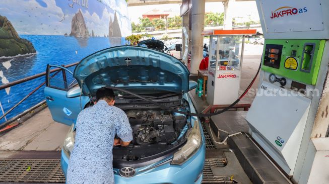 Petugas melakukan pengisian Bahan Bakar Gas (BBG) di Stasiun Pengisian Bahan Bakar Gas (SPBG) Mampang, Jakarta Selatan, Jumat (13/5/2022). [Suara.com/Alfian Winanto]