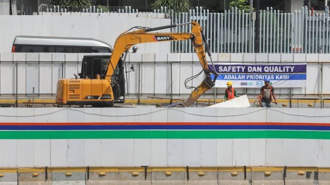 Para pekerja beraktivitas di proyek revitalisasi Halte TransJakarta Sarinah, Jakarta Pusat, Jumat (13/5/2022). [Suara.com/Alfian Winanto]
