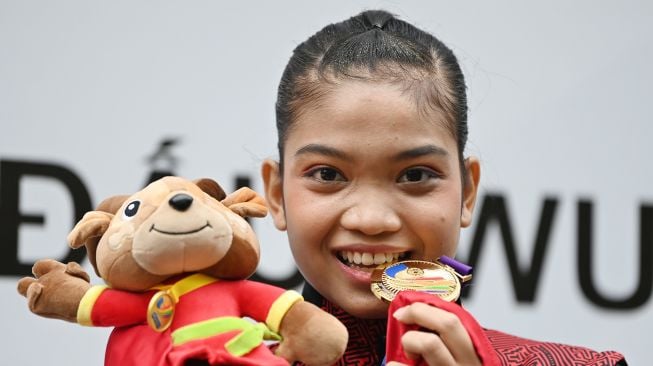 Pewushu Indonesia Alisya Mellynar berpose menggigit medalinya usai pengalungan medali nomor taolu taiji quan putri wushu SEA Games 2021 Vietnam di Cau Giay Gymnasium, Hanoi, Vietnam, Sabtu (14/5/2022).  ANTARA FOTO/Aditya Pradana Putra