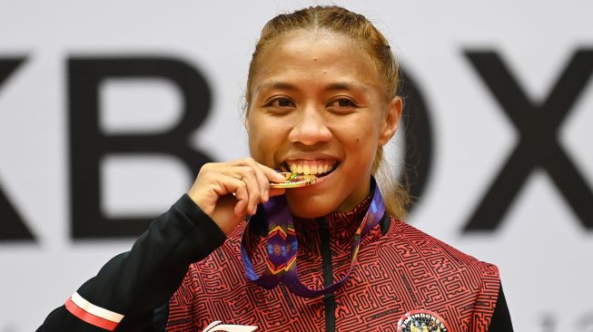 Atlet Indonesia Pieter Diandra Ariesta mengigit medalinya usai mengalahkan lawannya asal Filipina Cordero Gretel De Paz dalam pertandingan babak final kelas -56 kilogram putri nomor full contact Kickboxing SEA Games 2021 Vietnam di Bac Ninh Gymnasium, Bac Ninh, Vietnam, Jumat (13/5/2022).  ANTARA FOTO/Aditya Pradana Putra