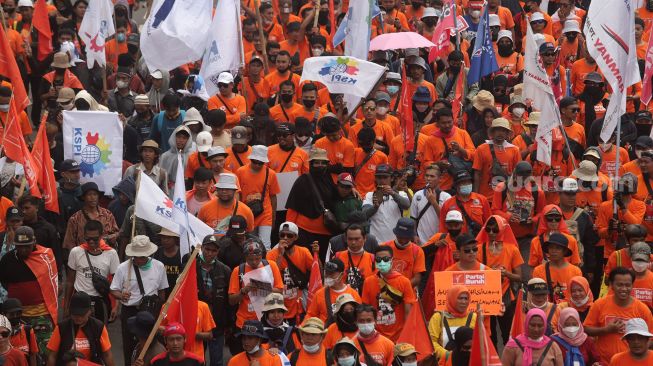 Sejumlah massa buruh melakukan 'long march' menuju Stadion Gelora Bung Karno usai berunjuk rasa di depan gedung DPR RI, Jakarta, Sabtu (14/5/2022). [Suara.com/Angga Budhiyanto]