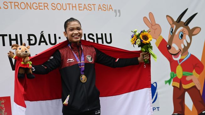 Pewushu Indonesia Alisya Mellynar membawa bendera Merah Putih usai pengalungan medali nomor taolu taiji quan putri wushu SEA Games 2021 Vietnam di Cau Giay Gymnasium, Hanoi, Vietnam, Sabtu (14/5/2022). ANTARA FOTO/Aditya Pradana Putra