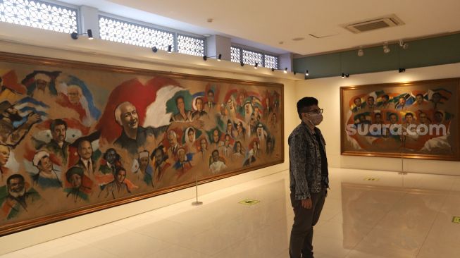 Pengunjung mengamati lukisan yang dipajang di Museum Basoeki Abdullah, Jakarta, Sabtu (14/5/2022). [Suara.com/Angga Budhiyanto]