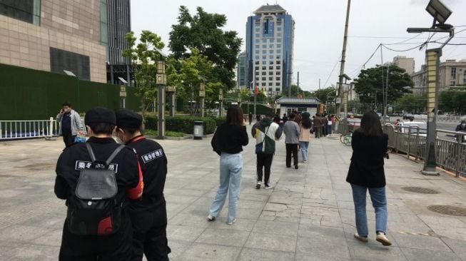 Sejumlah warga antre mengikuti tes PCR massal putaran ketiga di kawasan Dongzhimen, Beijing, China, Jumat (13/5/2022), untuk menghindari makin meluasnya wabah COVID-19 varian Omicron. ANTARA/M. Irfan Ilmie