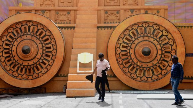 Pekerja memberikan sentuhan akhir pada sebuah instalasi di Taman Bollywood di Filmcity Mumbai, India, Jumat (13/5/2022). [SUJIT JAISWAL / AFP]