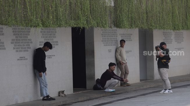 Warga berfoto di Taman Lapangan Banteng, Jakarta, Senin (16/5/2022). [Suara.com/Angga Budhiyanto]