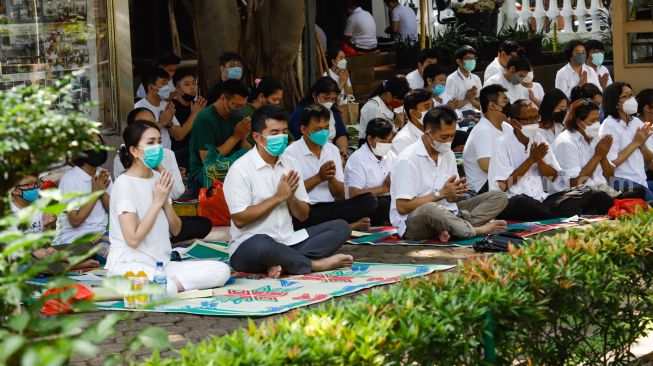 Umat Buddha melakukan ibadah Hari Raya Tri Suci Waisak di Vihara Jakarta Dhammacakka Jaya, Jakarta Utara, Senin (16/5/2022). [Suara.com/Alfian Winanto]