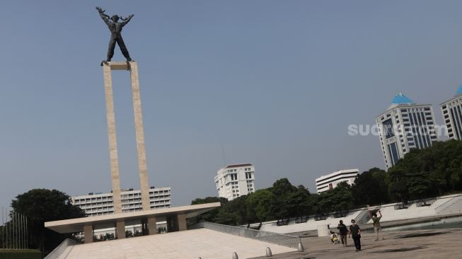 Warga berjalan di Taman Lapangan Banteng, Jakarta, Senin (16/5/2022). [Suara.com/Angga Budhiyanto]