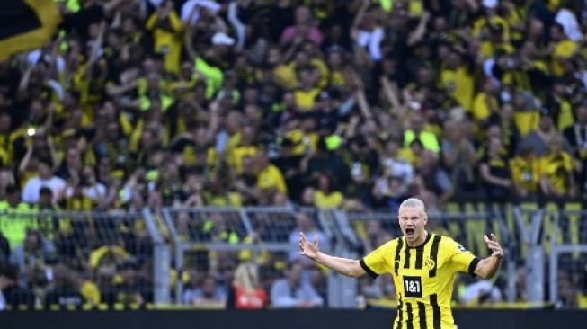 Erling Haaland rayakan gol ke gawang Hertha Berlin dalam pertandingan Bundesliga yang digelar di Signal Iduna Park, Sabtu (14/5/2022). [AFP]