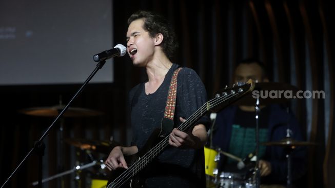 Penyanyi Abdul Qodir Jaelani tampil bersama dengan band barunya, Qodir saat acara konferensi pers pelepasan album baru berjudul Seribu Bulan di Hard Rock Cafe Pacific Place, Jakarta, Senin (16/5/2022). [Suara.com/Angga Budhiyanto]