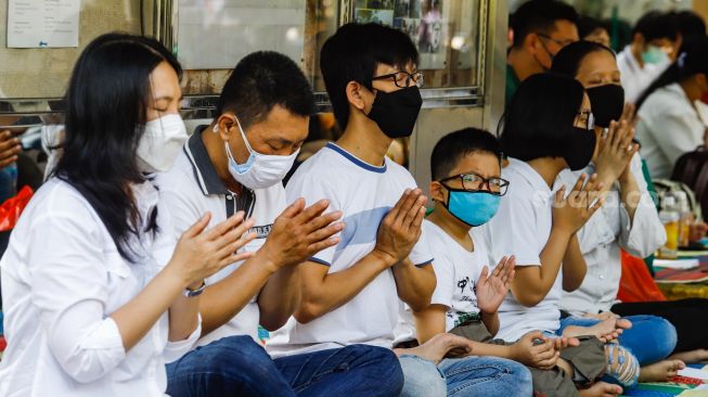 Umat Buddha melakukan ibadah Hari Raya Tri Suci Waisak di Vihara Jakarta Dhammacakka Jaya, Jakarta Utara, Senin (16/5/2022). [Suara.com/Alfian Winanto]