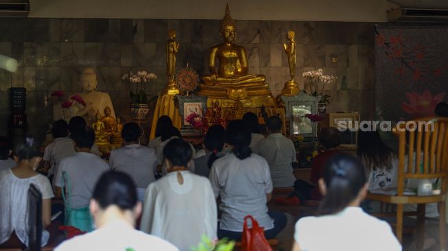 Umat Buddha melakukan ibadah Hari Raya Tri Suci Waisak di Vihara Jakarta Dhammacakka Jaya, Jakarta Utara, Senin (16/5/2022). [Suara.com/Alfian Winanto]