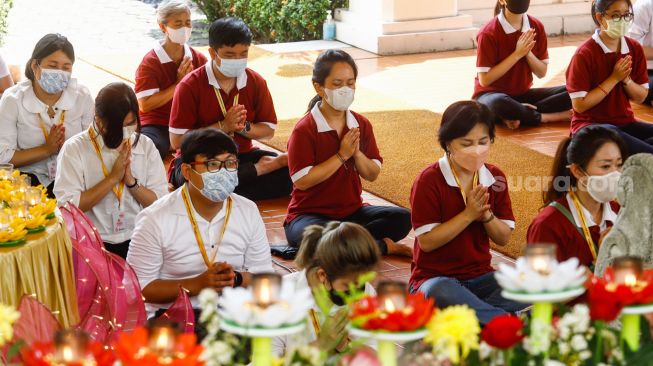 Umat Buddha melakukan ibadah Hari Raya Tri Suci Waisak di Vihara Jakarta Dhammacakka Jaya, Jakarta Utara, Senin (16/5/2022). [Suara.com/Alfian Winanto]