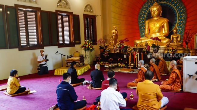 Umat Buddha melakukan ibadah Hari Raya Tri Suci Waisak di Vihara Jakarta Dhammacakka Jaya, Jakarta Utara, Senin (16/5/2022). [Suara.com/Alfian Winanto]