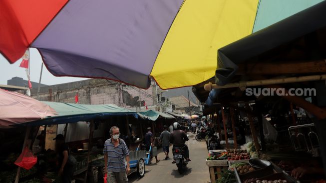 Pedagang melayani pembeli di Pasar Petak Sembilan, Glodok, Jakarta, Senin (16/5/2022). [Suara.com/Angga Budhiyanto]